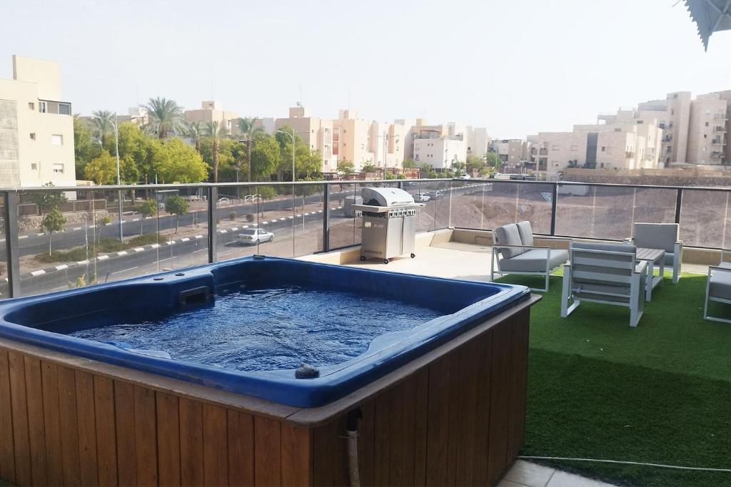 a hot tub on a balcony with a view of a city at YalaRent Seasons 4 bedroom apartment with jacuzzi in Eilat