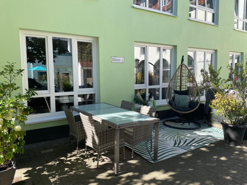eine Terrasse mit einem Tisch und Stühlen vor einem Gebäude in der Unterkunft Patio 1 in Bremen