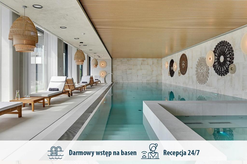 a hospital lobby with a swimming pool and benches at GRANO APARTMENTS Solmarina SPA & Wellness in Wiślinka
