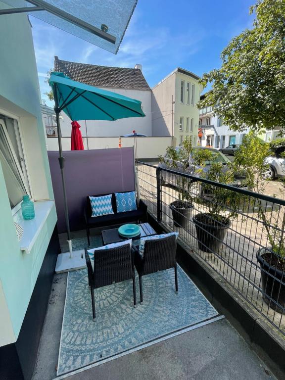 einen Balkon mit einem Tisch, Stühlen und einem Sonnenschirm in der Unterkunft Patio 2 in Bremen