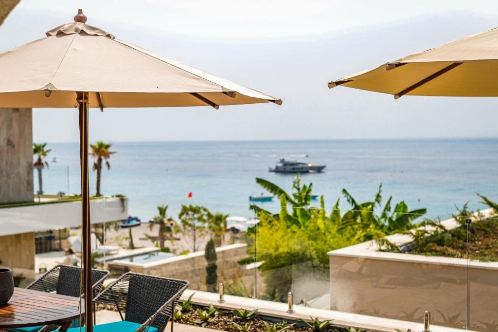 a view of the ocean from a beach with umbrellas at Drymades Inn Resort in Dhërmi