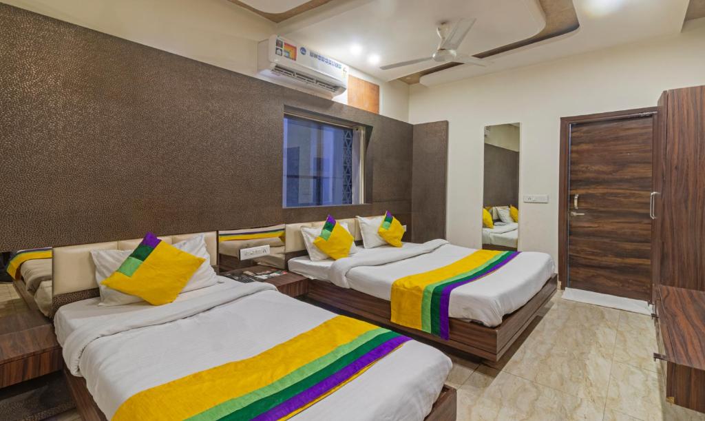 een hotelkamer met 2 bedden en kleurrijke kussens bij Itsy By Treebo - Shree Anand Dham, Vrindavan in Vrindāvan