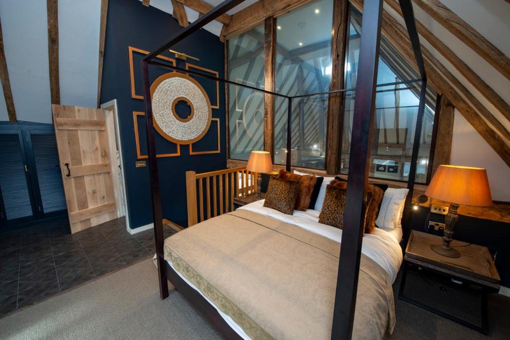1 dormitorio con cama con dosel y ventana en Cloth Worker's Barn, en Smarden