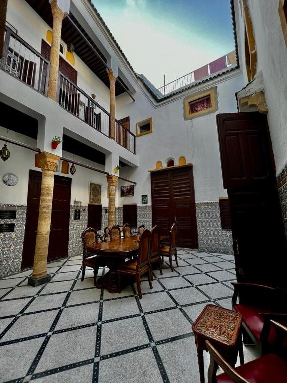 a room with a table and chairs in a building at Riad Le Palais in Rabat