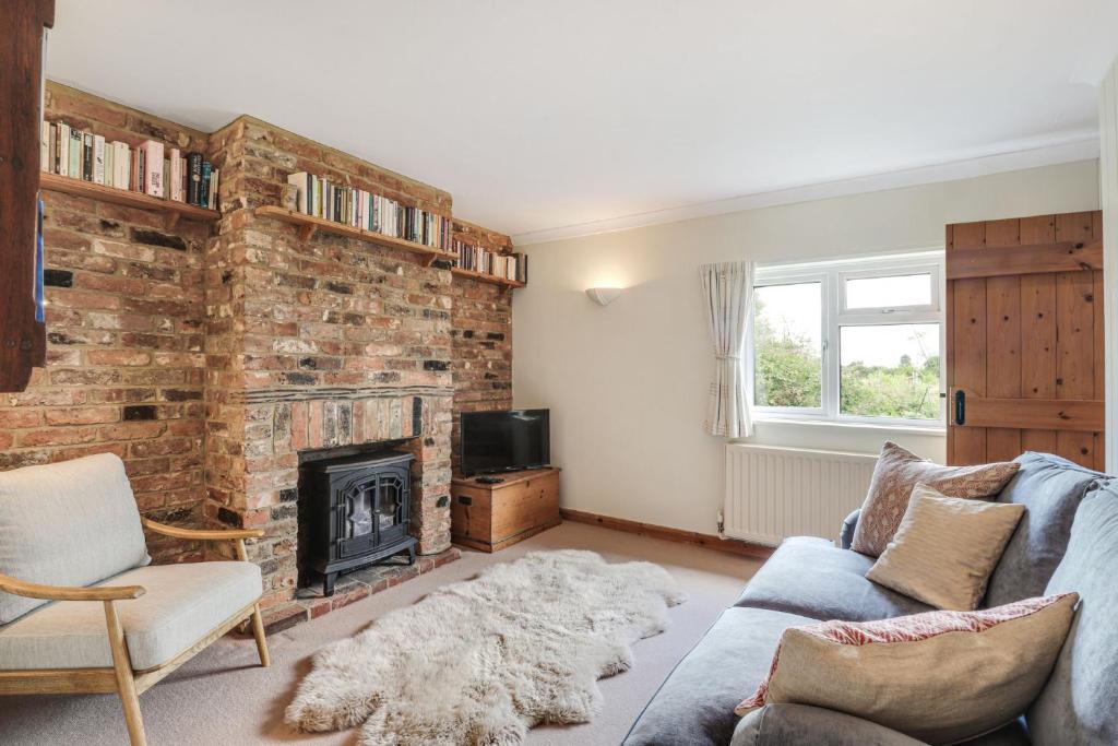 a living room with a fireplace and a blue couch at Pass the Keys Cosy Countryside Cottage in Tonbridge