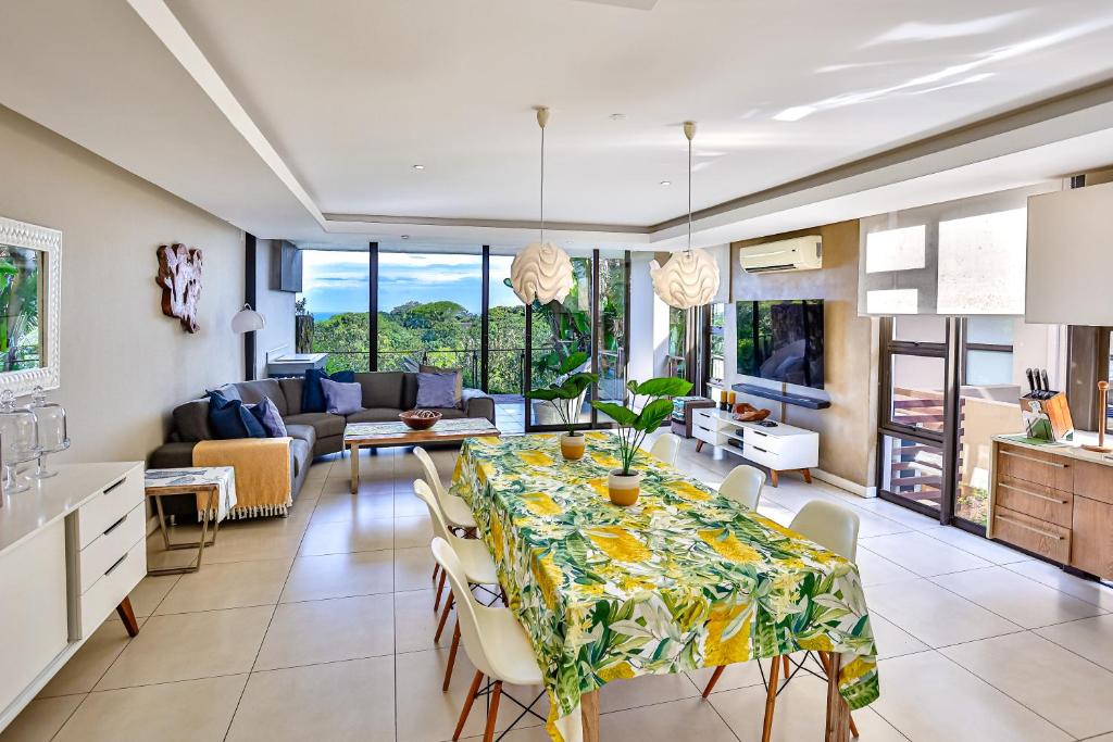 a dining room and living room with a table and chairs at Holiday home in Zimbali in Ballito
