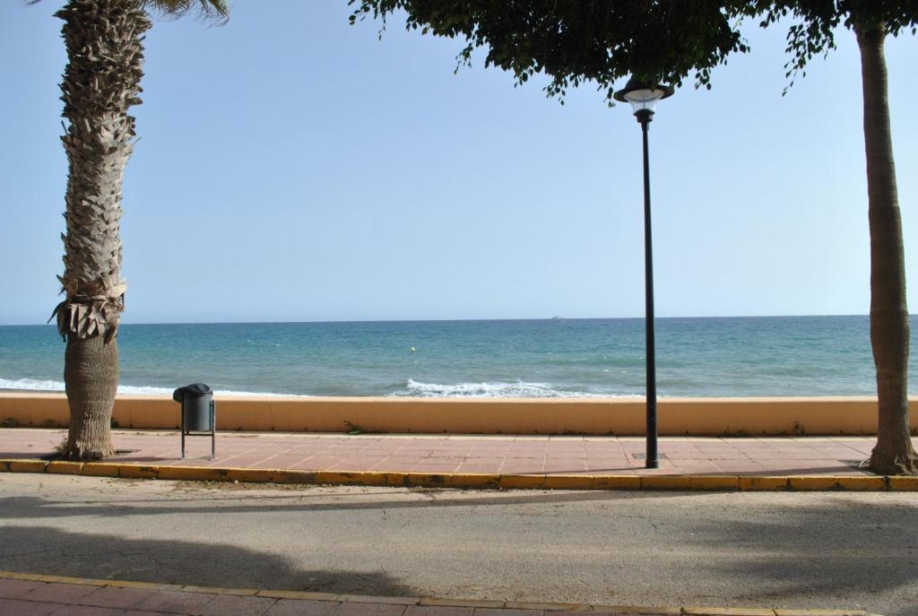 an empty street with the ocean in the background at Apartamentos la Caracola in Adra