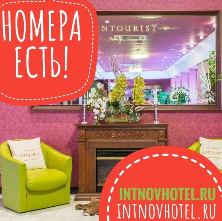 a living room with a yellow chair and a fireplace at Intourist Hotel in Velikiy Novgorod