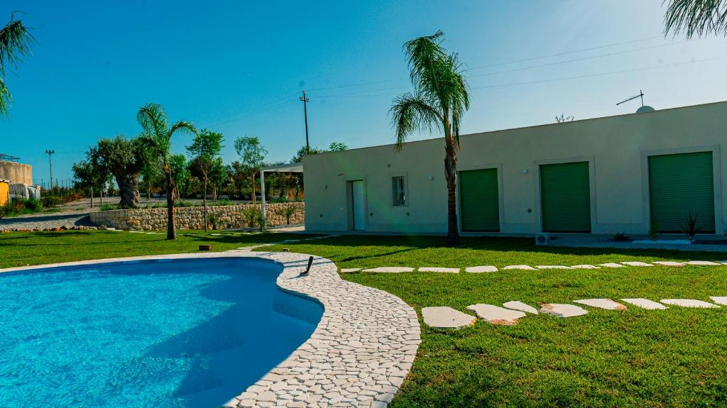 a swimming pool in a yard next to a building at Dimora Mediterranea in Augusta