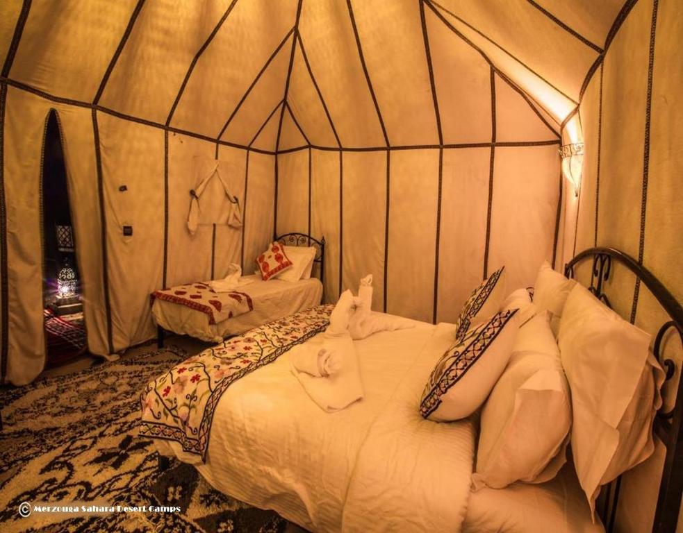 Postel nebo postele na pokoji v ubytování Merzouga Luxury Sahara Camps