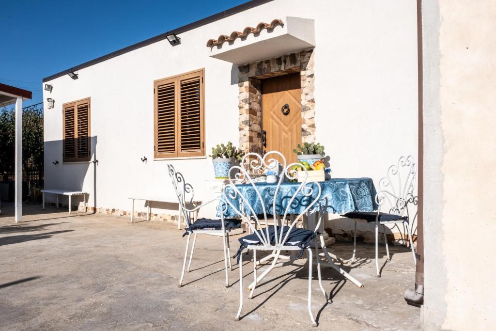 Un posto al sole - Caltanissetta في كالتانيسيتا: فناء به طاولة وكراسي أمام المنزل