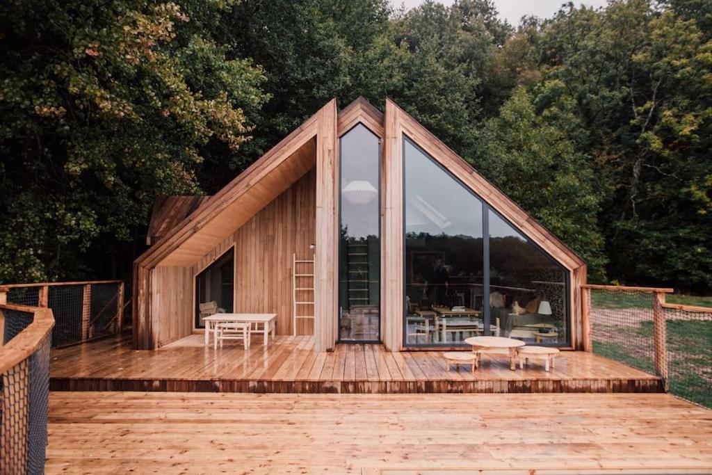 una piccola casa in legno con una grande finestra su una terrazza di Casa Friendly avec sa piscine chauffée … a Les Croix Chemins