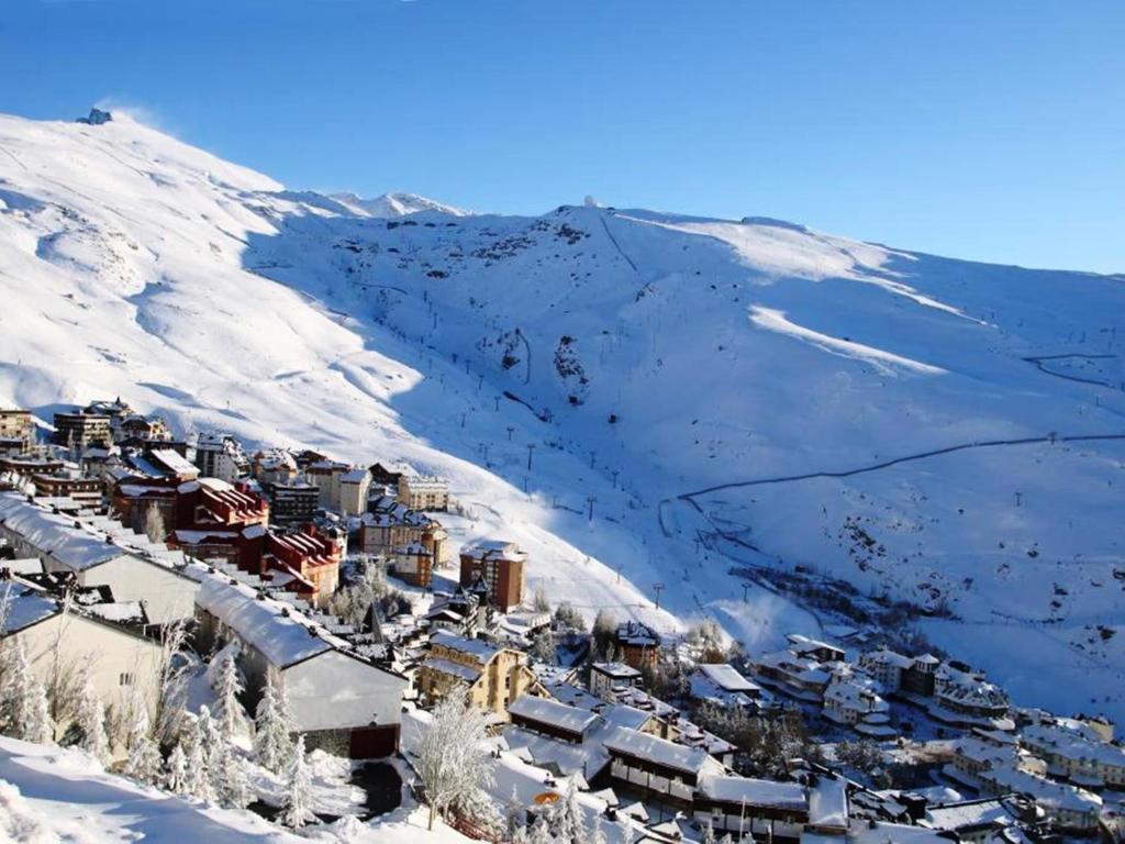 un pequeño pueblo en la nieve en una montaña en Apartamento Europa Sierra Nevada con garaje, en Sierra Nevada