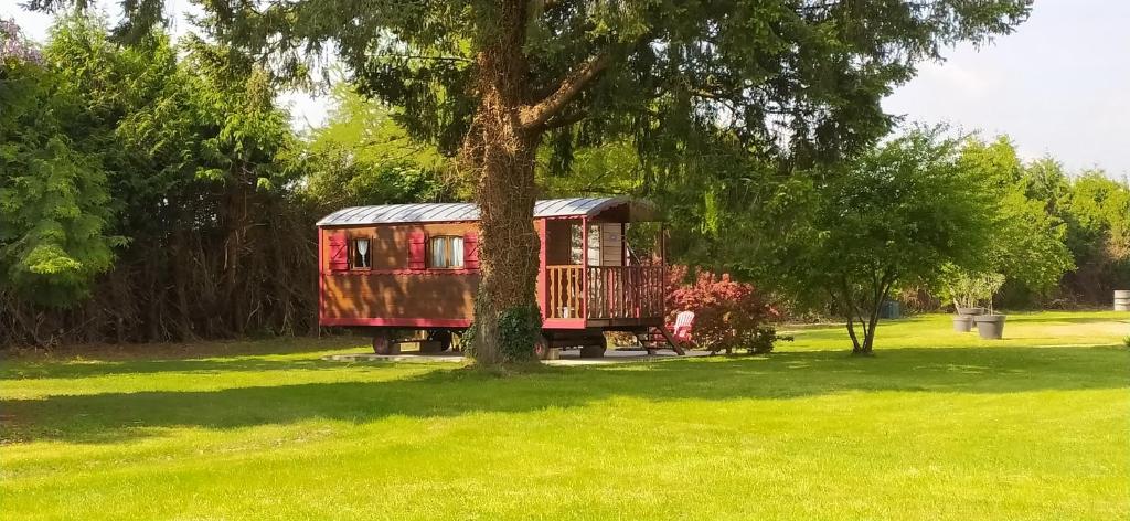 a red train car parked next to a tree at Domaine Moulin d'Elemiah in Gémozac