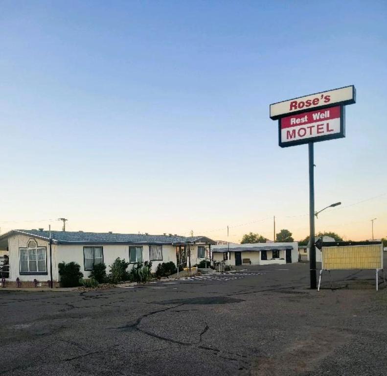 a motel sign in the middle of a parking lot at Rose's Motel in Willcox