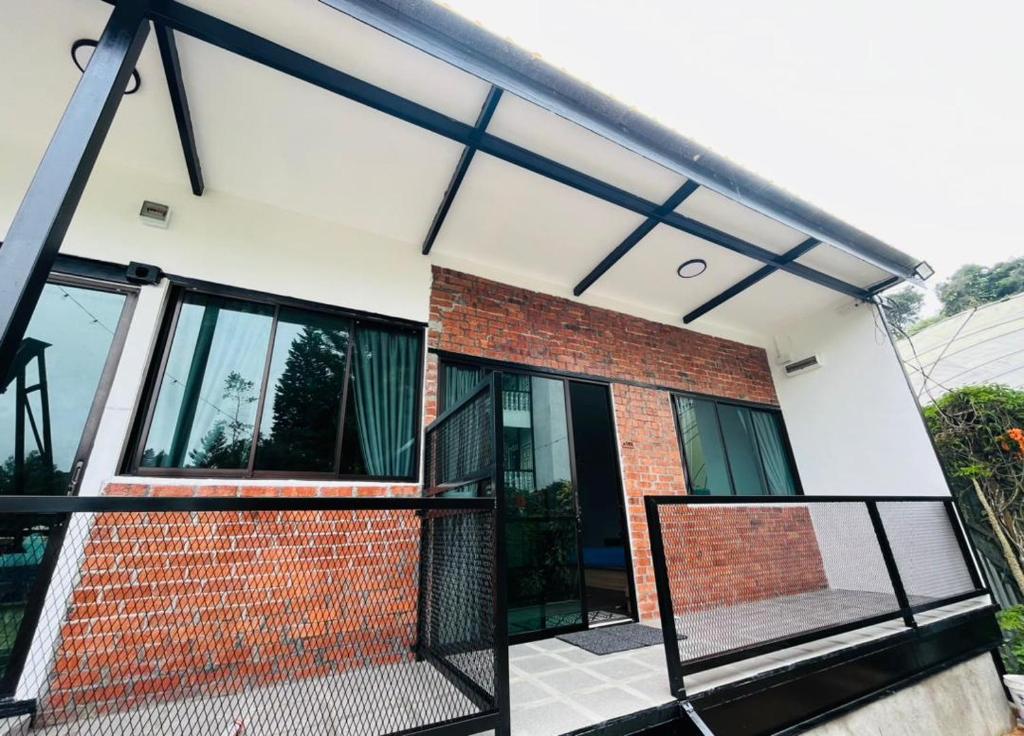 a brick house with black and white windows at Big Dreams Garden Stay in Tanah Rata