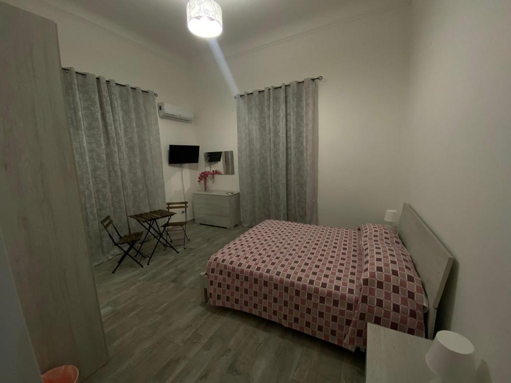 1 dormitorio con 1 cama y 1 mesa en una habitación en Casaiole2023, en Taranto