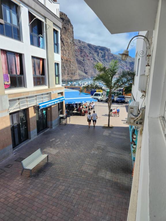 a city street with a bench and a mountain in the background at Vivienda Vacacional América in Valle Gran Rey