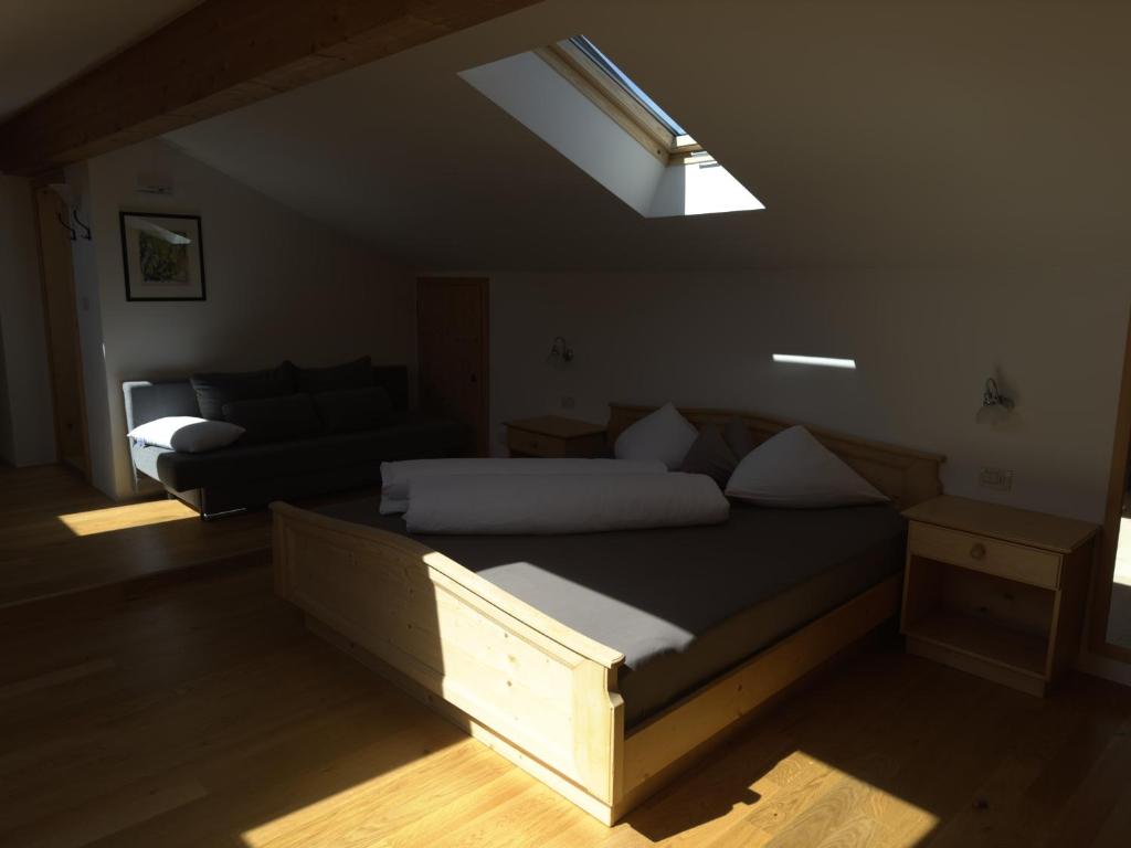 ein Schlafzimmer mit einem Bett und einem Dachfenster in der Unterkunft Garni Residence Trocker in Kastelruth