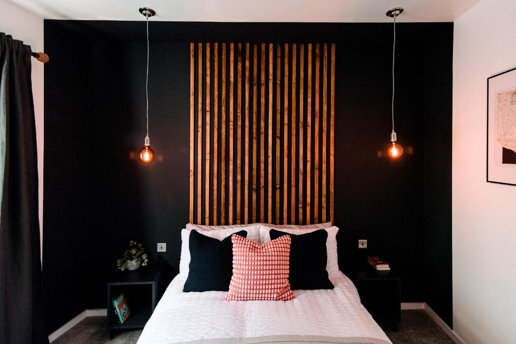 a bedroom with a black wall and a bed with pillows at Unique, stylish and secluded home, with parking in the heart of historic York in York