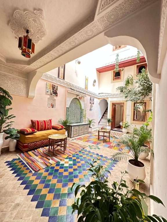 a living room with a couch and a rug at Dar Khmissa Fes in Fès