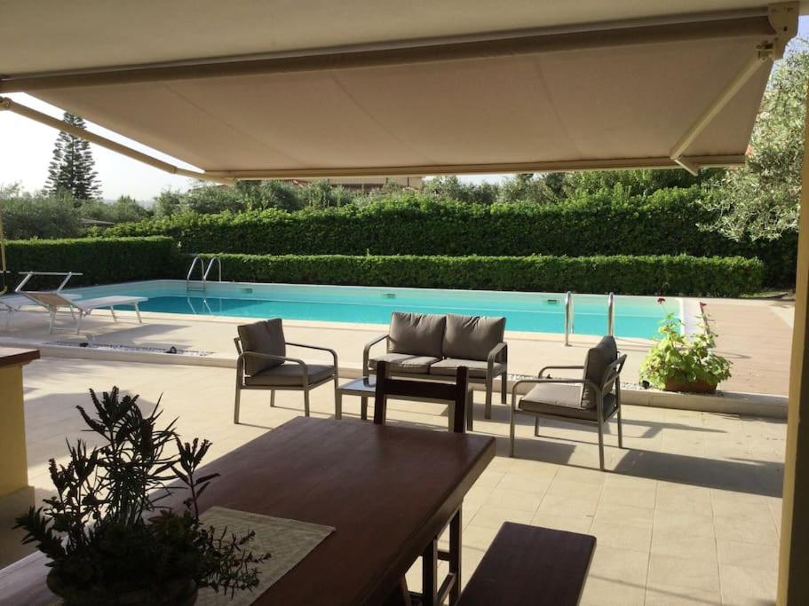 patio con sedie, tavolo e piscina di House with a swimming pool - Villa San Giorgio a Villa Gorizia