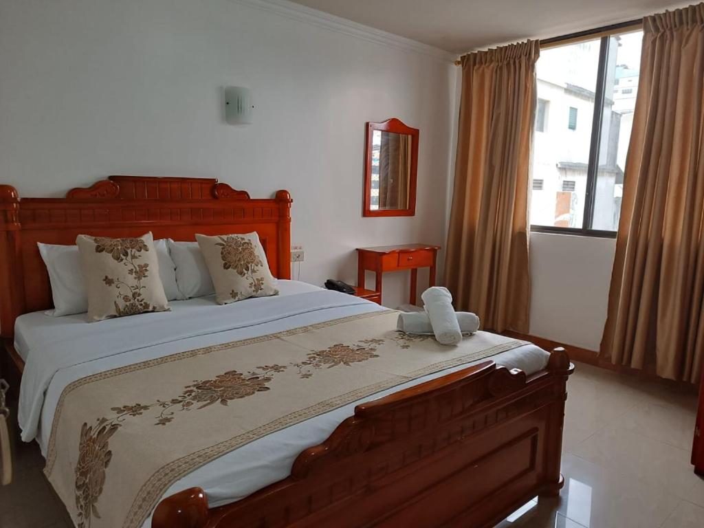 a bedroom with a large bed and a window at Hostal Bicentenario in Guayaquil