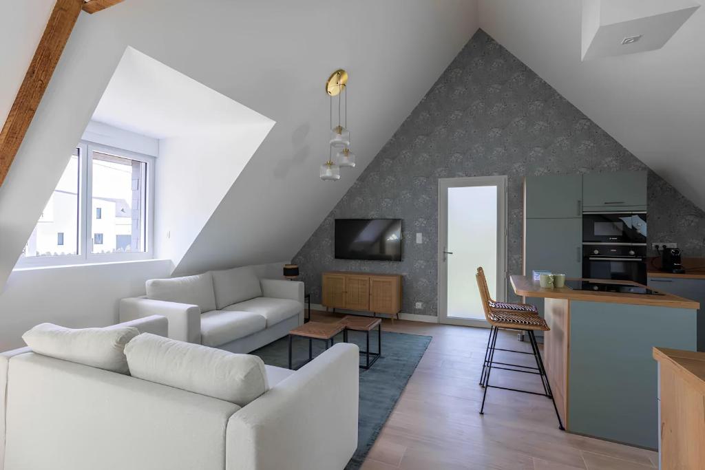 un soggiorno con divano bianco e una cucina di Appartement centre - La Gacilly a La Gacilly