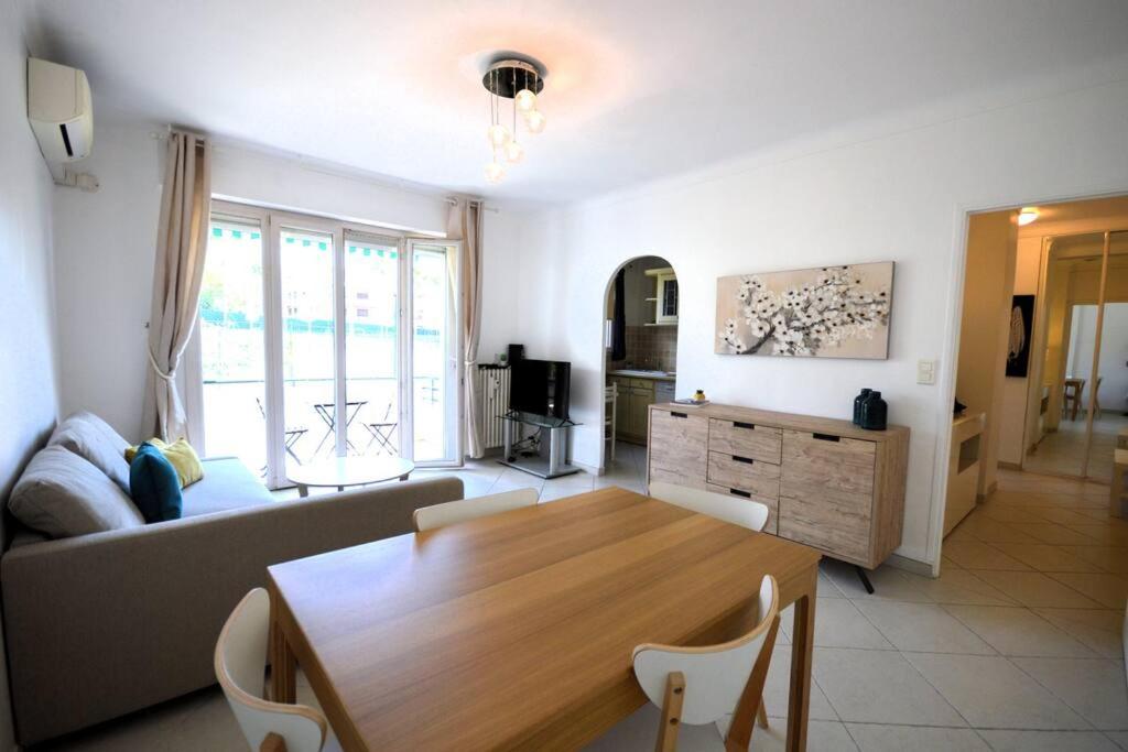 uma sala de estar com uma mesa e um sofá em Le Madrilien & Terrasse & Clim & 400M Croisette em Cannes