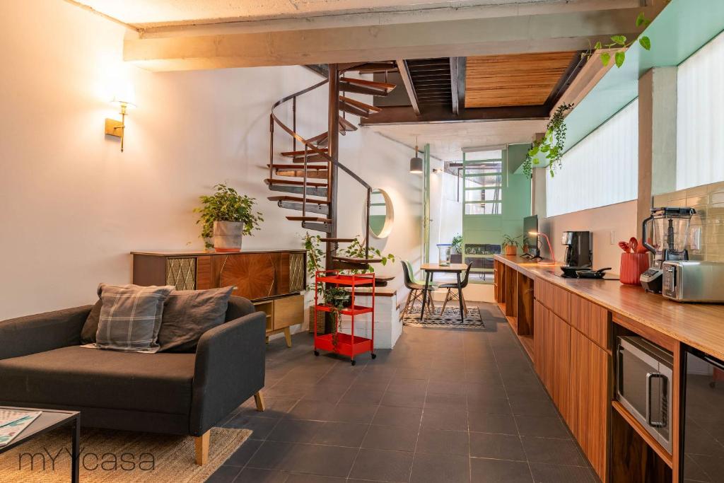 ein Wohnzimmer mit einem Sofa und einer Wendeltreppe in der Unterkunft Comfortable Apt. w/ Terrace & Lovely Lighting 101 in Mexiko-Stadt