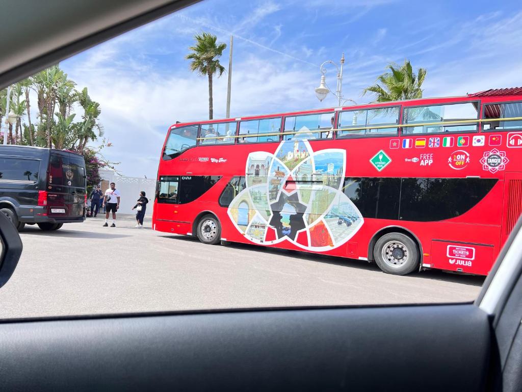 a red double decker bus parked on a street at The Paradise of ACHAKAR in Tangier