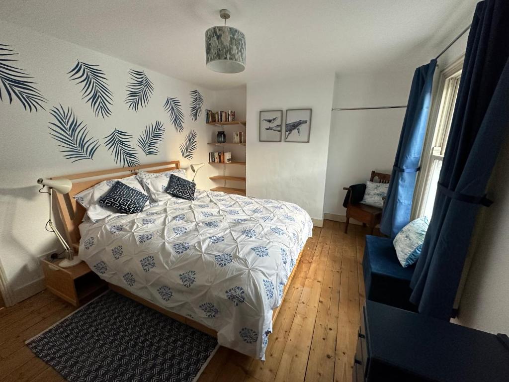 a bedroom with a bed with a blue and white comforter at Beautiful Victorian house in central Cambridge in Cambridge