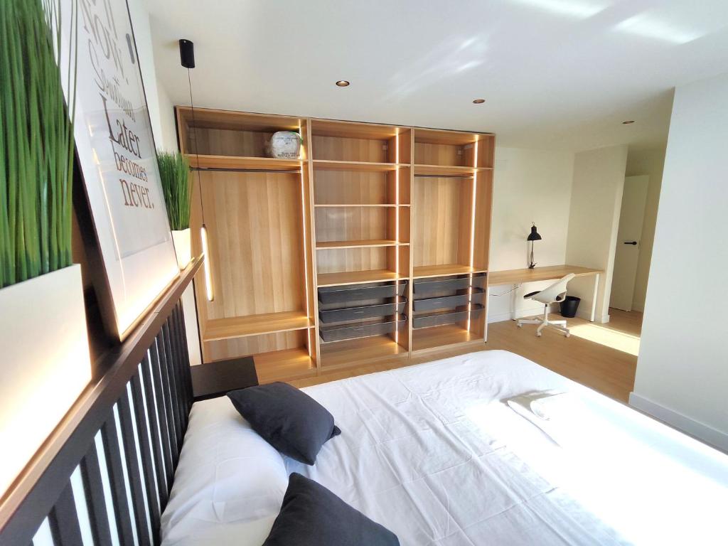 a bedroom with a bed and a wooden cabinet at Puertollano Central Park - by Pro Apartments - Free Parking in Puertollano