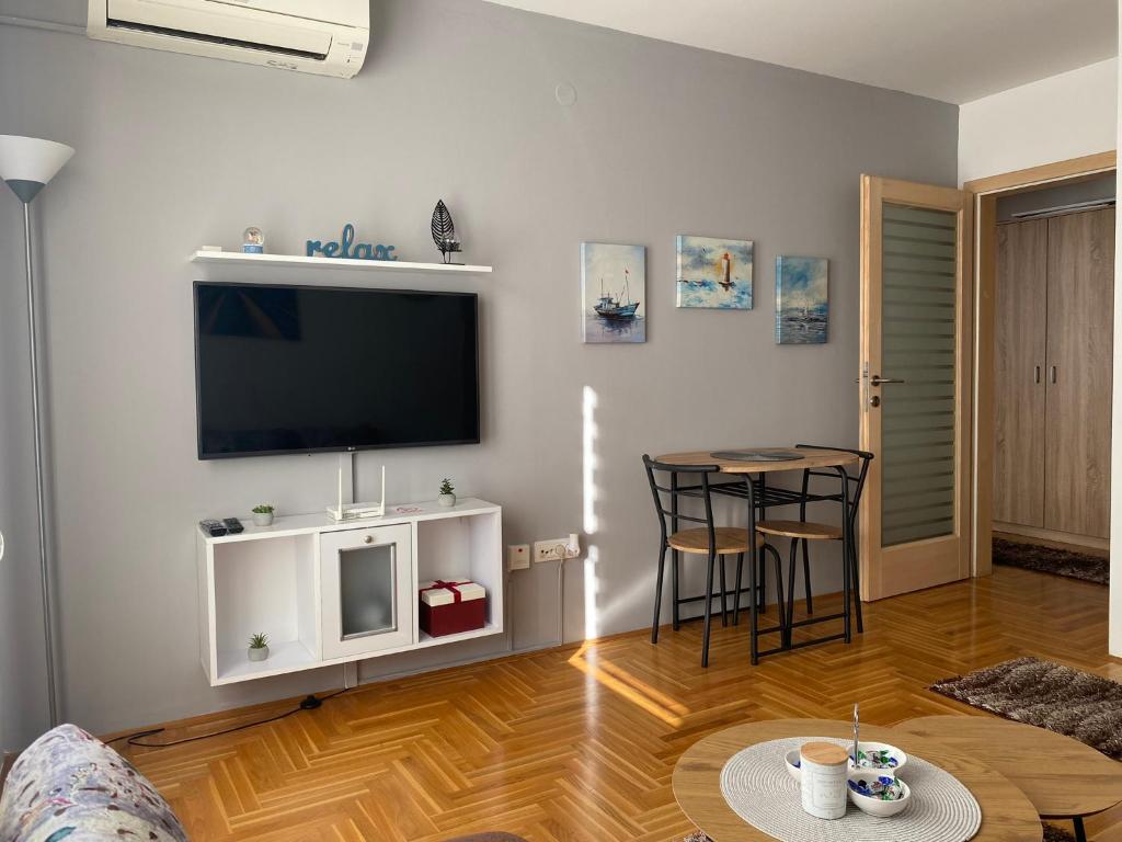 ein Wohnzimmer mit einem Flachbild-TV und einem Tisch in der Unterkunft Apartman Kalina in Donje Mladice