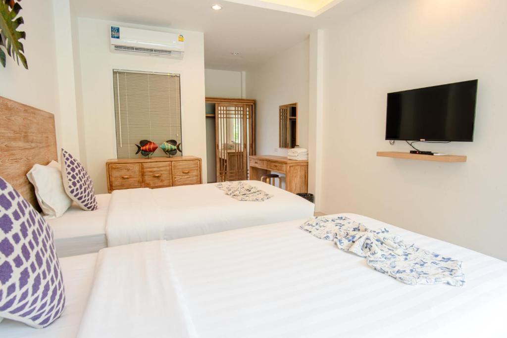 1 Schlafzimmer mit 2 Betten und einem Flachbild-TV in der Unterkunft Colorful Pool Villa in Ban Chin Tham Mai
