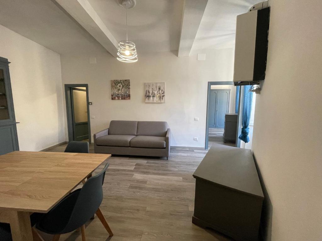 ein Wohnzimmer mit einem Tisch und einem Sofa in der Unterkunft appartamento dell'anfiteatro in Spoleto