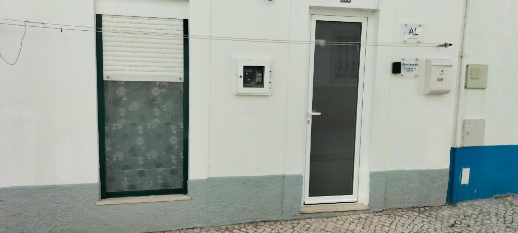 a white building with a door and a window at Apartamento Cavaleiro in Nazaré