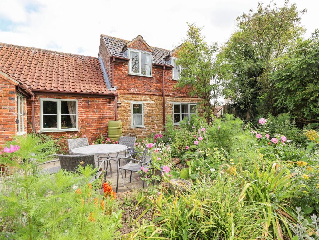 a garden in front of a house with a table and chairs at The Waggon Shed in Nottingham