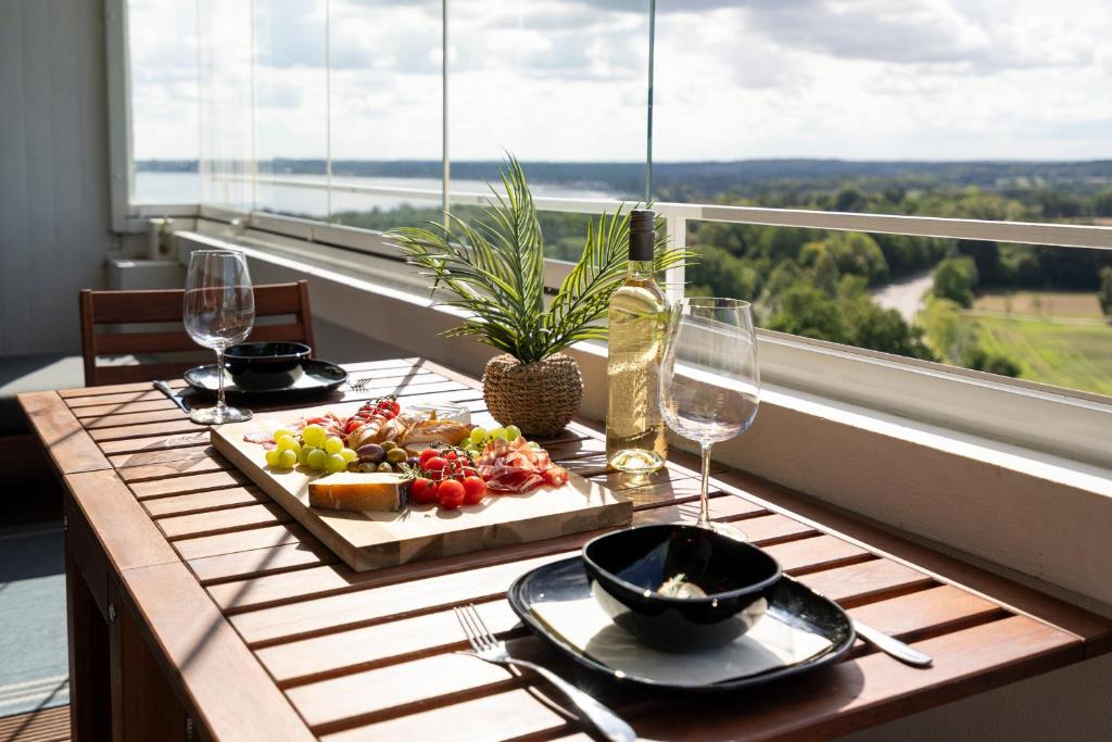 un tavolo con un piatto di bicchieri da cibo e vino di "Penthouse Wolke 12" mit unglaublichem Ausblick - Meerblick a Sierksdorf