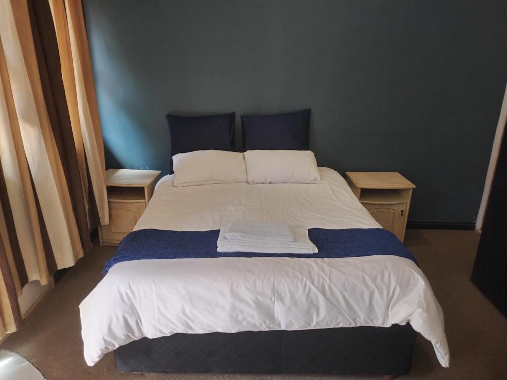 a bedroom with a large bed with two tables at 54 Brecher in Pretoria