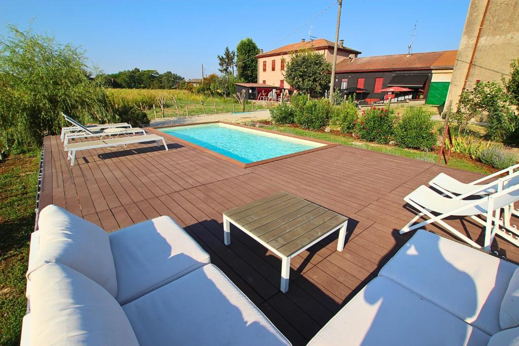 - une piscine avec un banc, une table et des chaises dans l'établissement Le Maginot Relais, 