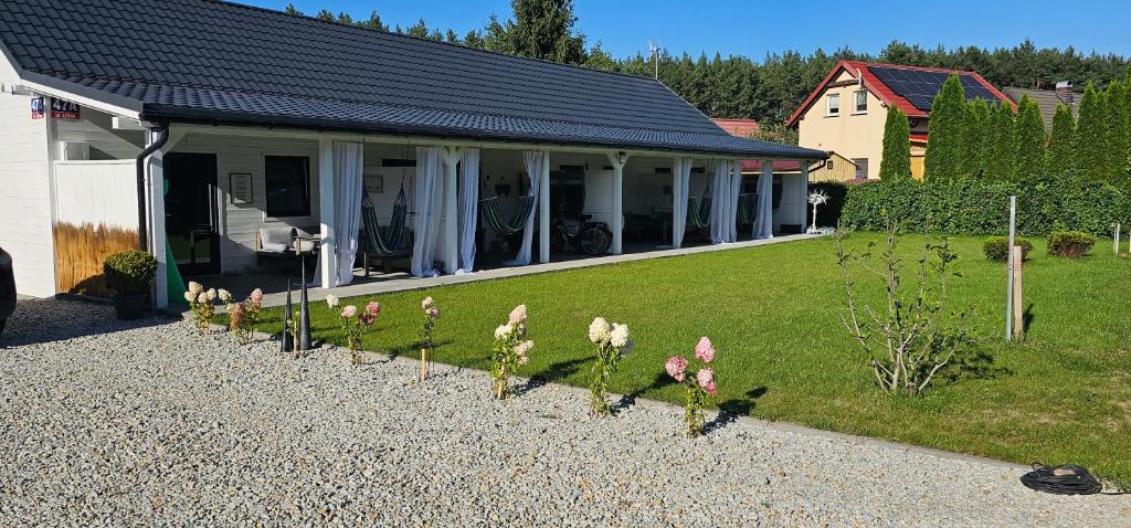 a house with a garden with flowers in the yard at Apartamenty Carpe Diem in Sława