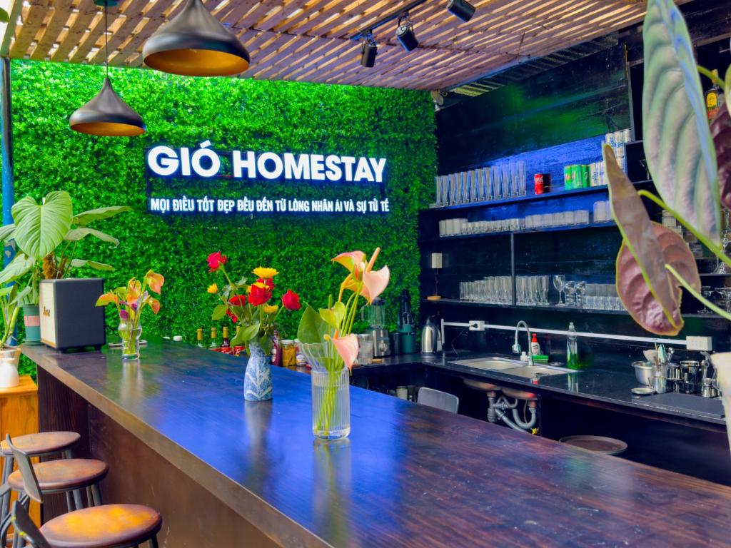 a bar in a restaurant with a green wall at Gió Homestay in Xuan An