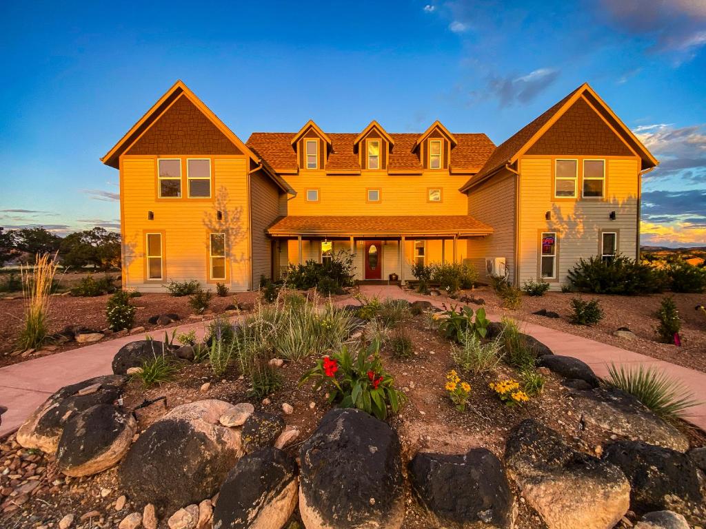 a large yellow house with a landscaping at SkyRidge Inn in Torrey