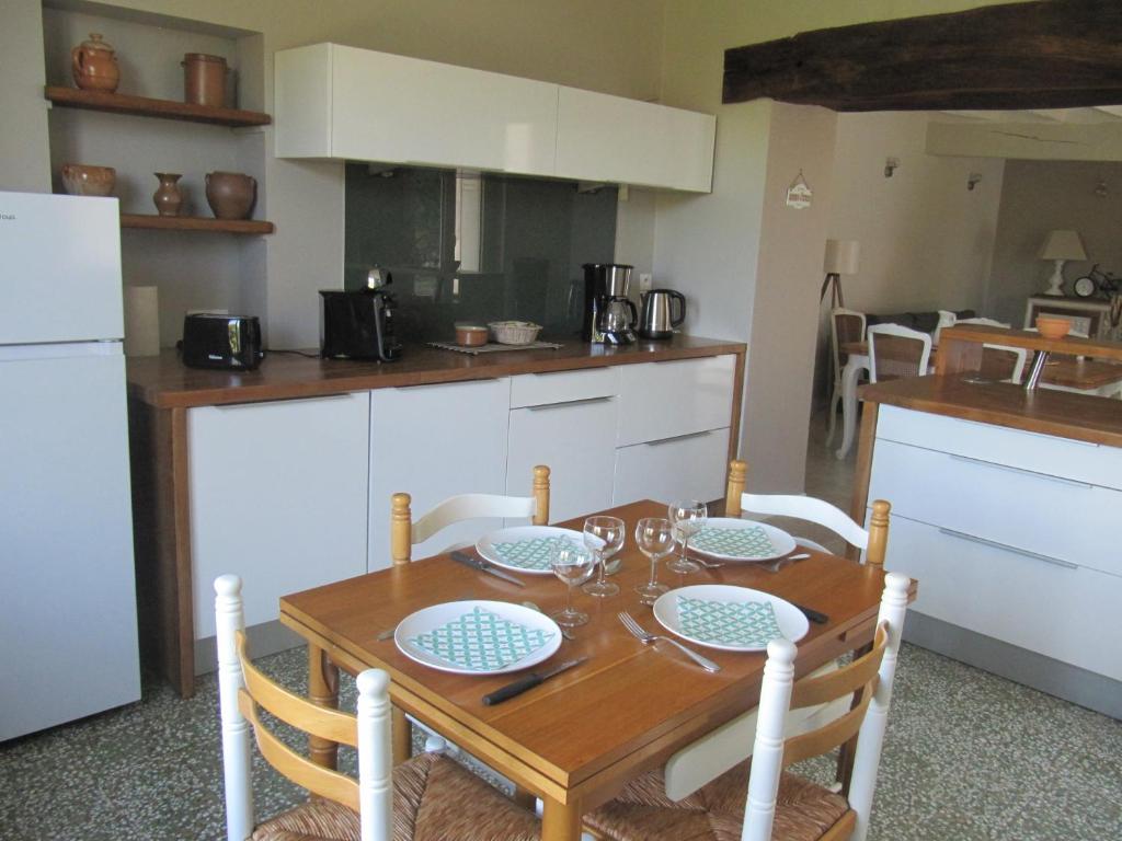 a kitchen with a wooden table with chairs and a table and a table andheastern at Les Ecureuils 4 / 6 personnes in Seigy