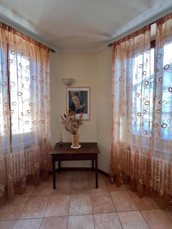 a room with curtains and a table with a vase at B&B Terra & Sole in Novafeltria