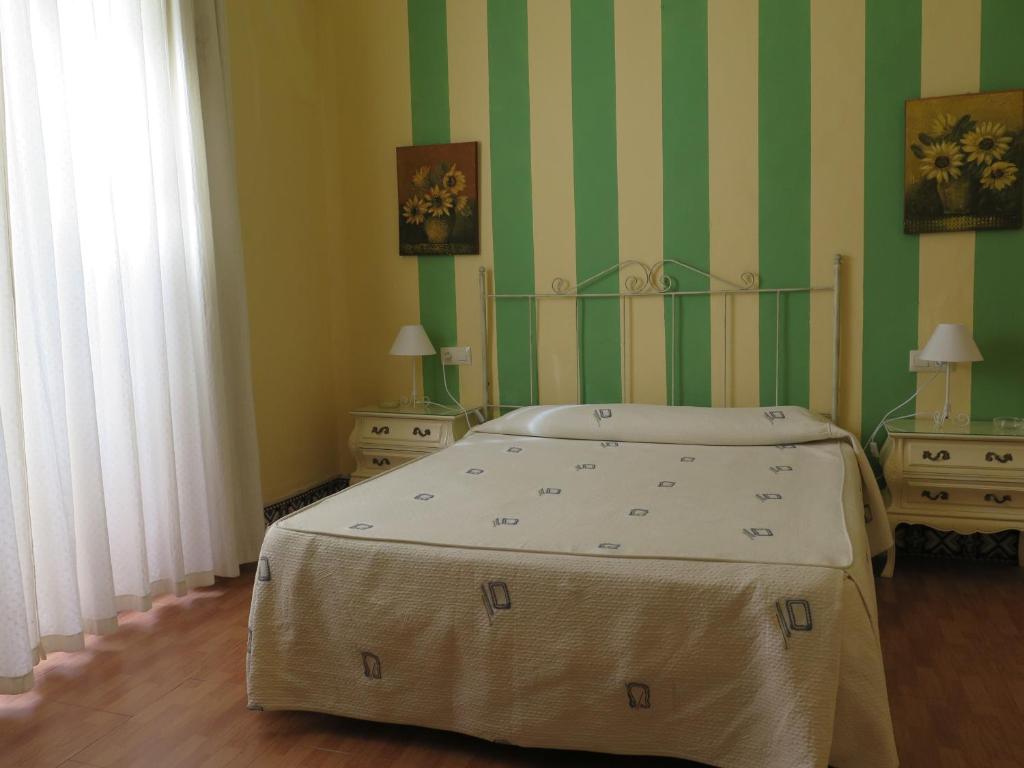 a bedroom with a bed and a dresser at Pensión Bienvenido in Seville