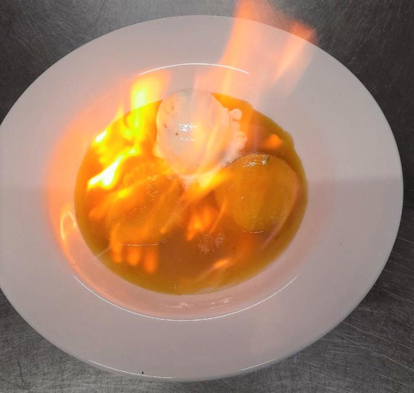 a white plate with a bowl of caramel on a table at Firefly Estate Bequia in Crescent Beach