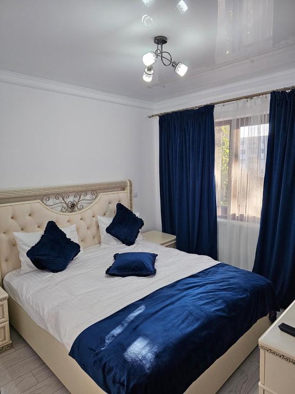 ein Schlafzimmer mit einem großen Bett mit blauen Kissen in der Unterkunft APARTAMENT 12 RO&MARIO BARLAD in Bîrlad