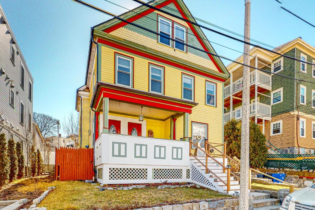 een geel en rood huis met een hek ervoor bij A Little Piece of History in Boston